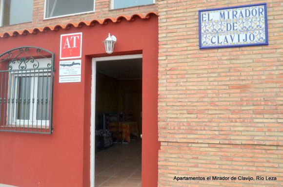 Puerta de entrada a un edificio con letrero del lugar y número de calle visible.